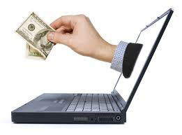 laptop with hand holding money